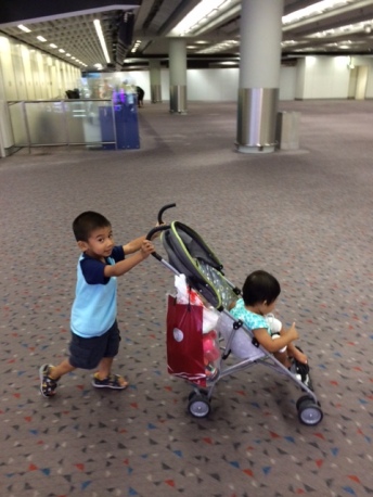Pushing his sister around HK Airport
